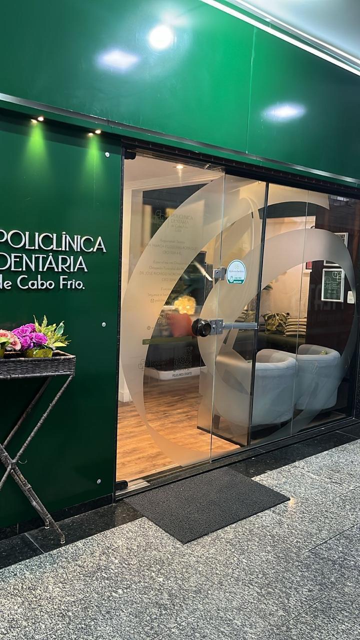 Fachada verde da Policlínica Dentária de Cabo Frio na Rua Raul Veiga, 409, Loja 05, Centro de Cabo Frio, com recepção iluminada
